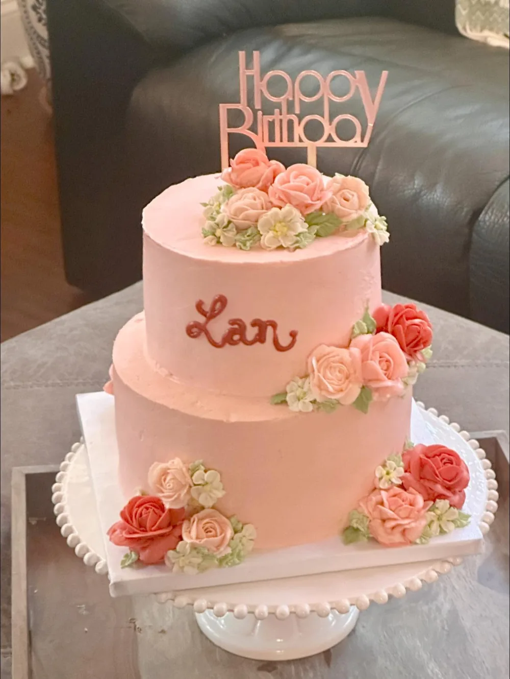 A two-tier pink birthday cake for Lan, with coral and peach buttercream roses and a Happy Birthday topper